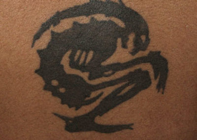 Tattoo of a Sound system logo on a dark skinned boy.