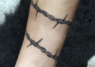 Tattoo of barbed wire on Rachels's leg.